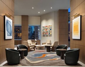 Lobby seating area with modern chairs, artwork, and warm lighting at Hyatt Regency Times Square.