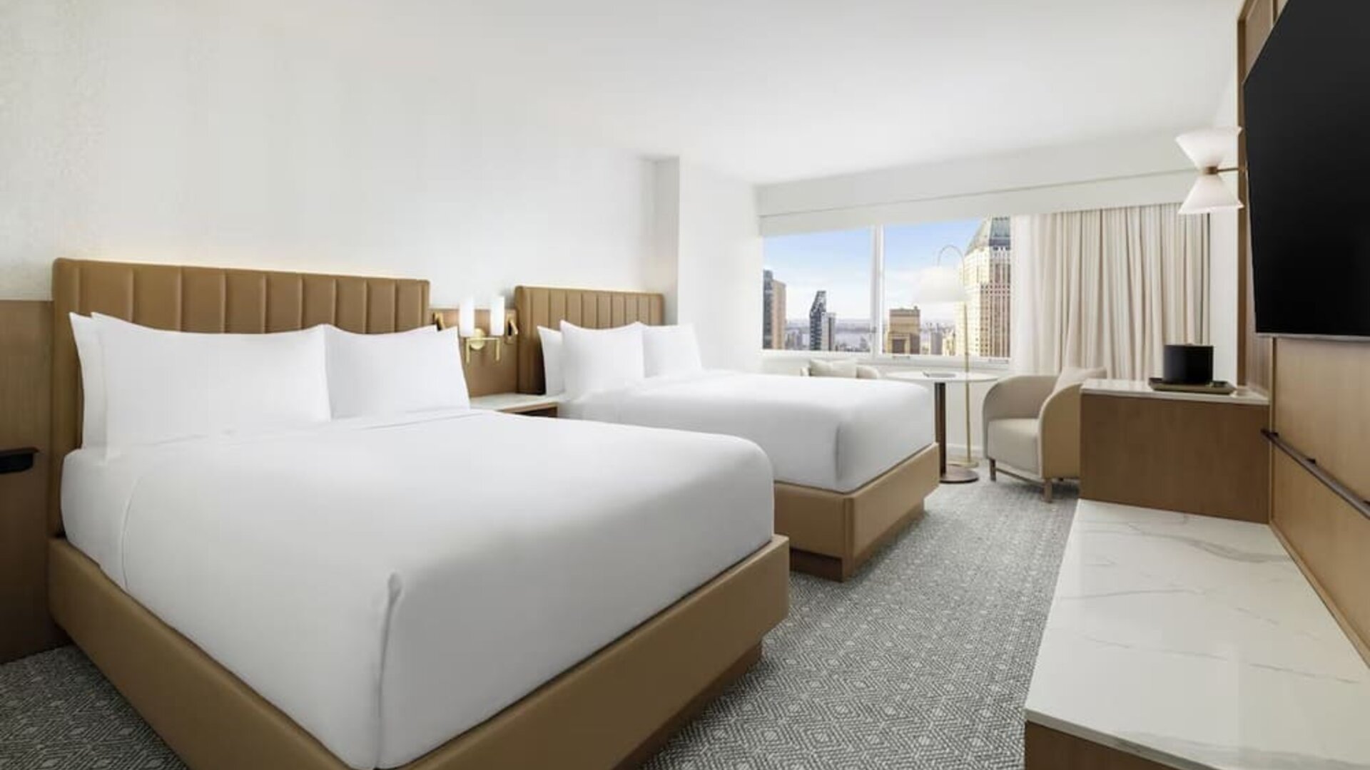Guest room with two beds, seating, and city views at Hyatt Regency Times Square.