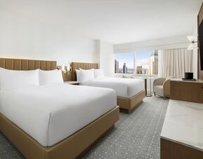 Guest room with two beds, seating, and city views at Hyatt Regency Times Square.