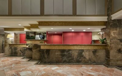 Reception desk area with marble finishes and warm lighting at The Michelangelo New York.