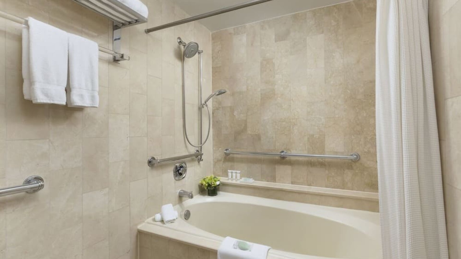 Bathroom with soaking tub, shower combination, and marble tile finishes at The Michelangelo New York.