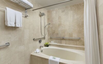 Bathroom with soaking tub, shower combination, and marble tile finishes at The Michelangelo New York.