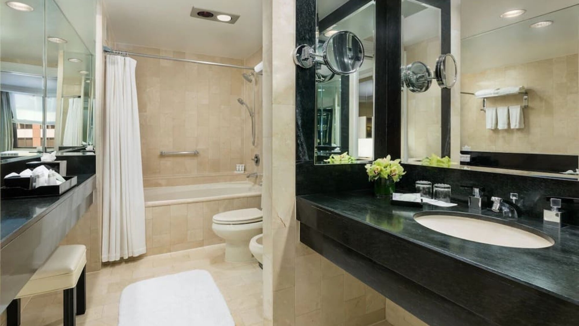 Bathroom with large vanity, mirror lighting, and marble finishes at The Michelangelo New York.