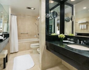 Bathroom with large vanity, mirror lighting, and marble finishes at The Michelangelo New York.