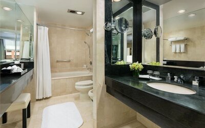 Bathroom with large vanity, mirror lighting, and marble finishes at The Michelangelo New York.