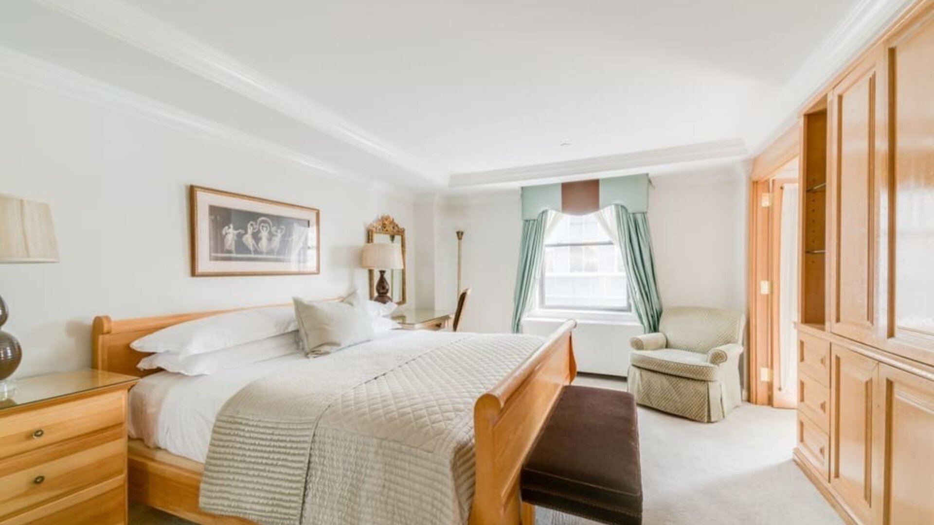 Spacious bedroom with king bed, seating area, and elegant decor at The Michelangelo New York.