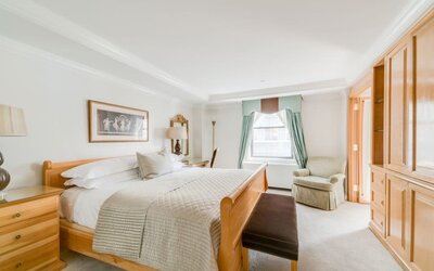 Spacious bedroom with king bed, seating area, and elegant decor at The Michelangelo New York.