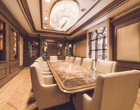 Meeting room with long conference table, chandelier lighting, and wood-paneled walls at The Michelangelo New York.