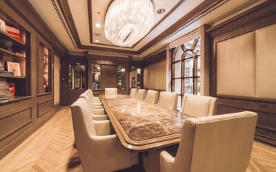 Meeting room with long conference table, chandelier lighting, and wood-paneled walls at The Michelangelo New York.
