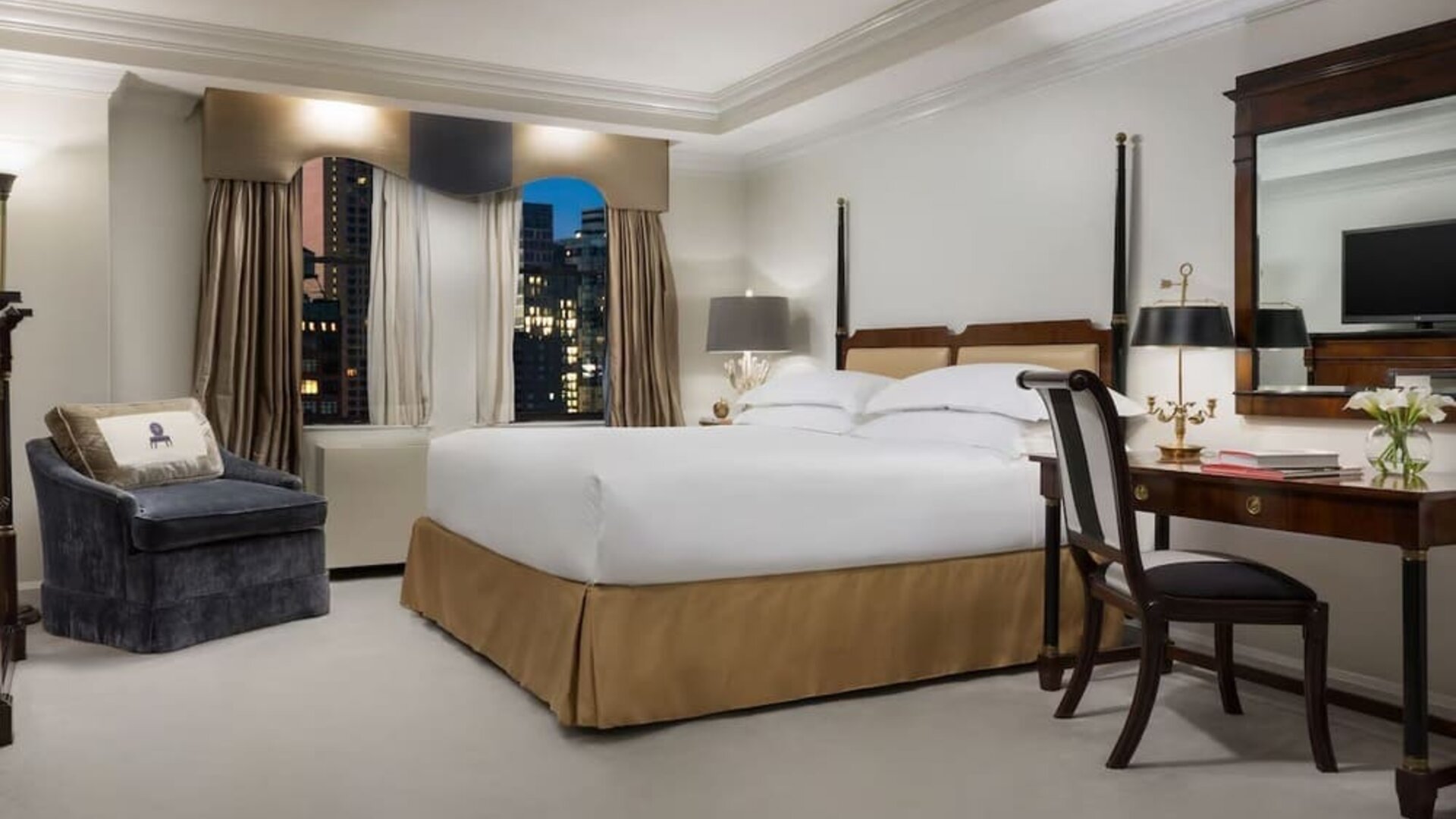 King bedroom with warm tones, desk area, and refined classic styling at The Michelangelo New York.