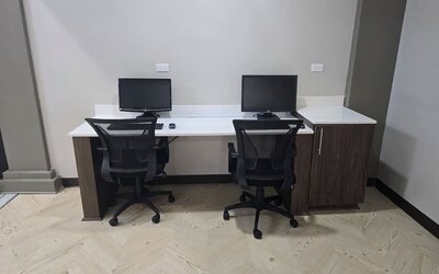 Business center with dual workstations, desktop computers, and ergonomic seating at Wyndham Garden Williamsburg Busch Gardens Area.