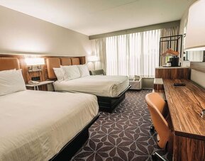 Double room with two beds, workspace, and modern decor at Wyndham Garden Williamsburg Busch Gardens Area.