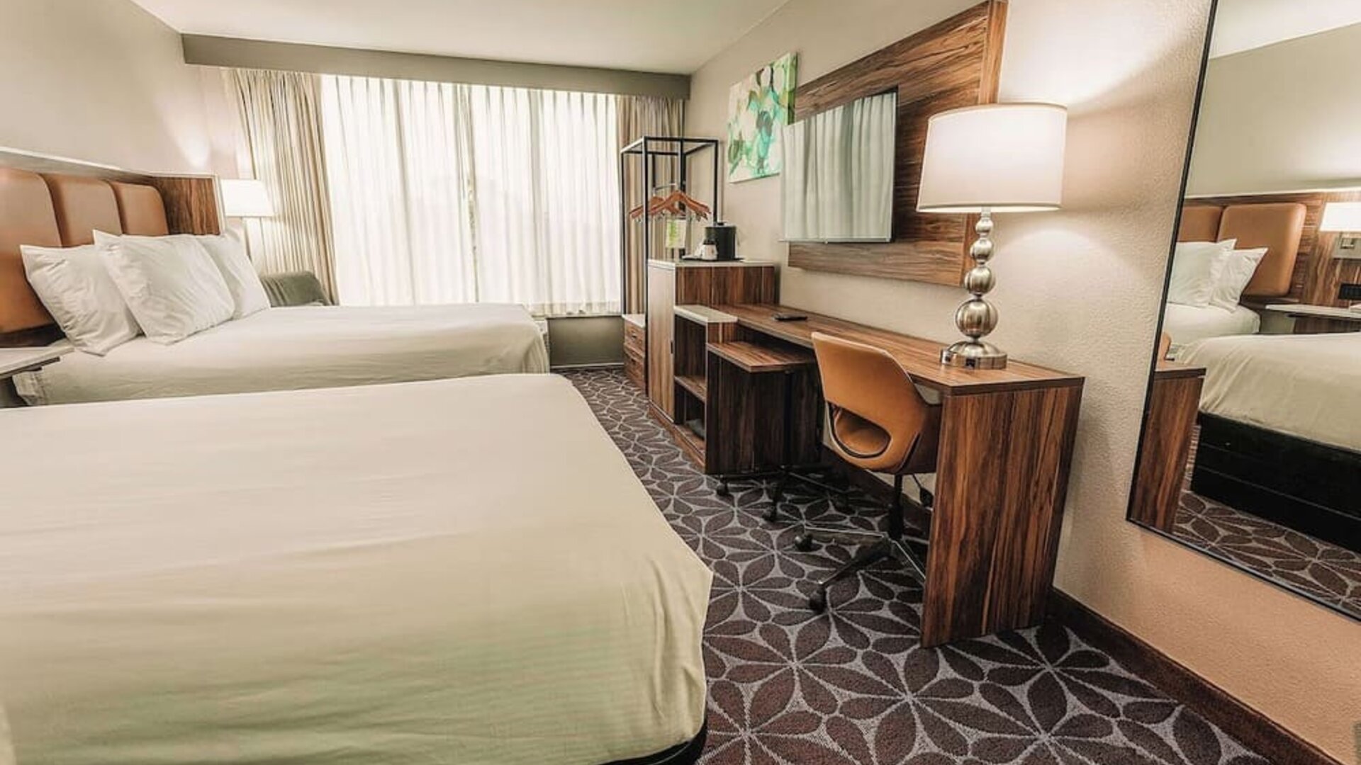 Two-bed guest room with desk, mirror, and contemporary design at Wyndham Garden Williamsburg Busch Gardens Area.