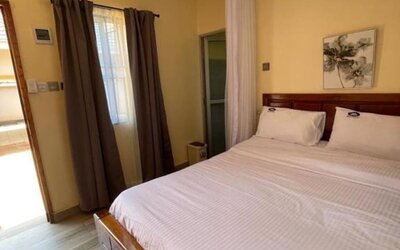 Comfortable bedroom with a large bed, soft linens, and warm lighting, offering a relaxing stay at Sega Lodge.
