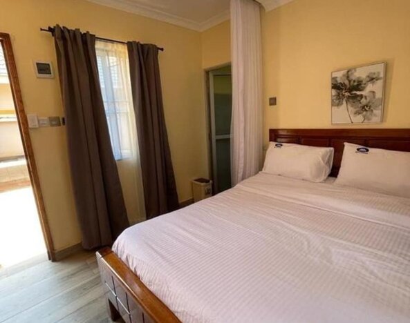 Comfortable bedroom with a large bed, soft linens, and warm lighting, offering a relaxing stay at Sega Lodge.
