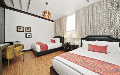 Guest room with two beds, patterned runners, bedside lamps, desk area, and wood flooring at Hotel Chelsea, A South Beach Group Hotel.