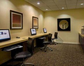 Business center with desktop computers, swivel chairs, long work counter, and printer station at DoubleTree By Hilton Los Angeles Downtown.