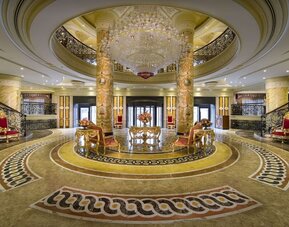 Grand lobby with circular layout, chandeliers, marble floors, and central seating arrangement
