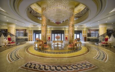Grand lobby with circular layout, chandeliers, marble floors, and central seating arrangement