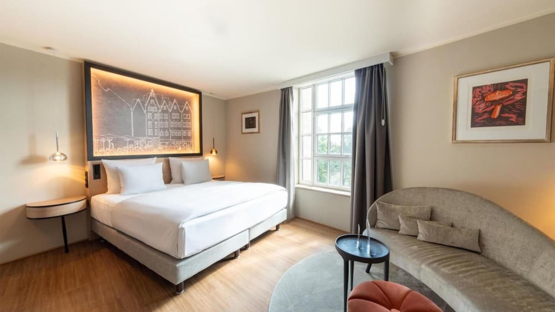 King bed with illuminated headboard art, wall shelving, desk area, and open layout with wood flooring
