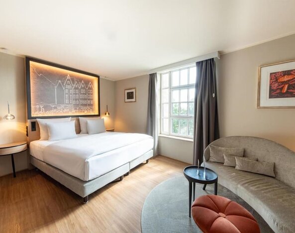 King bed with illuminated headboard art, wall shelving, desk area, and open layout with wood flooring