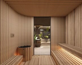 Wood-lined sauna room with bench seating, heated stones, and doorway to adjacent spa area