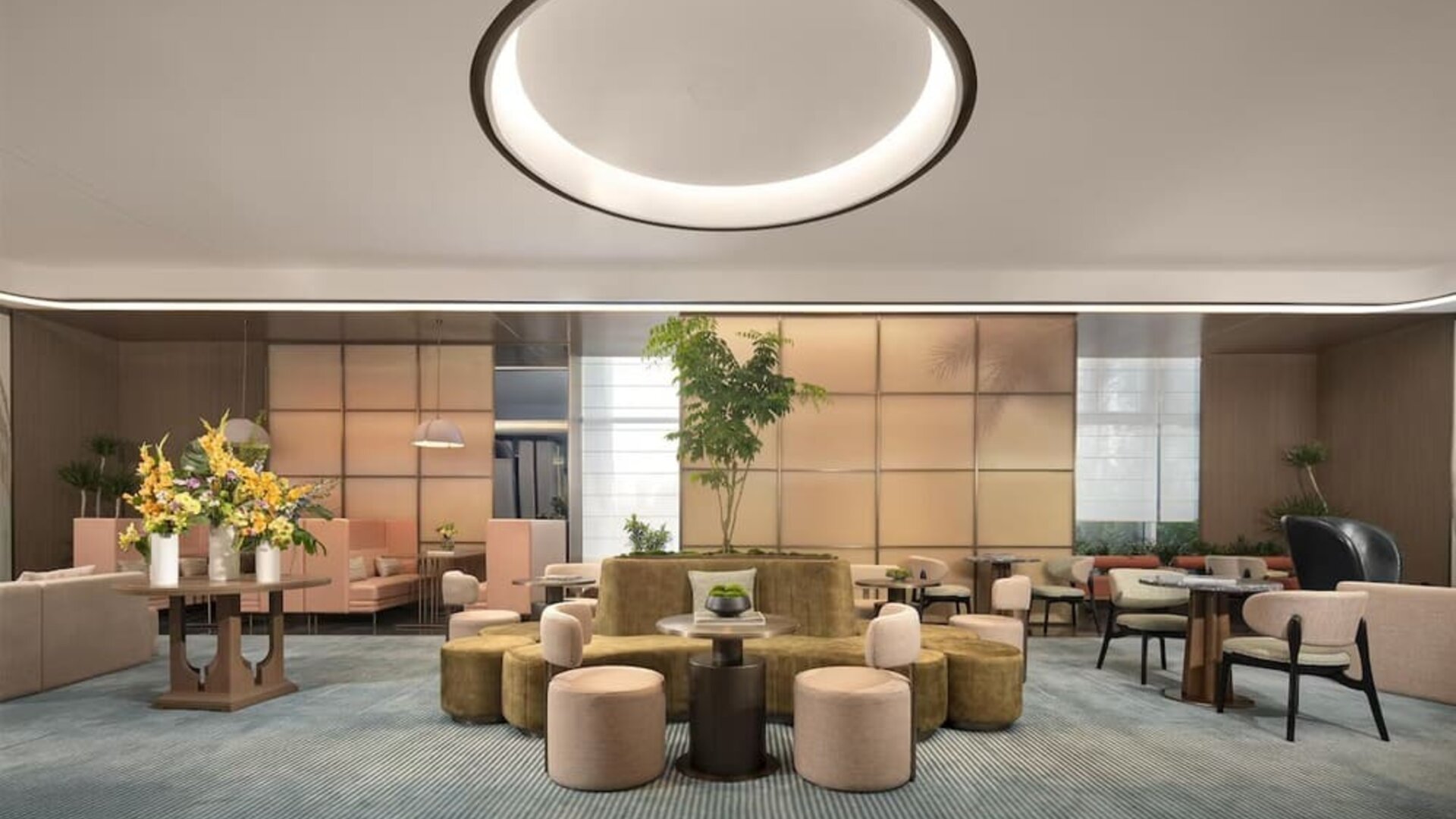 Contemporary lobby lounge with circular seating, floral arrangement, and soft ambient lighting