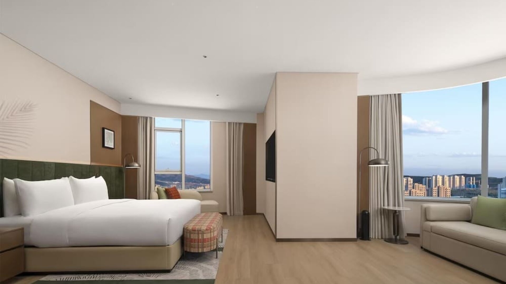 King bedroom with mountain and city views through corner windows, chaise lounge, and patterned bench