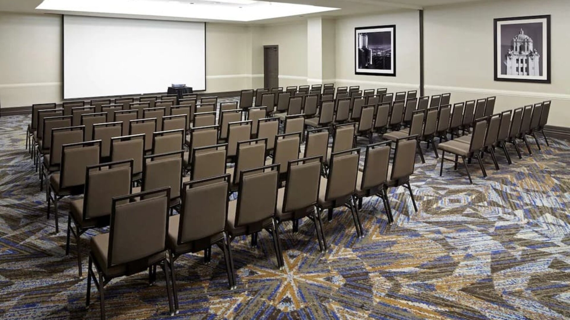 Large meeting and conference room with theater-style seating and projector screen at Embassy Suites By Hilton LAX Airport North.