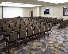 Large meeting and conference room with theater-style seating and projector screen at Embassy Suites By Hilton LAX Airport North.