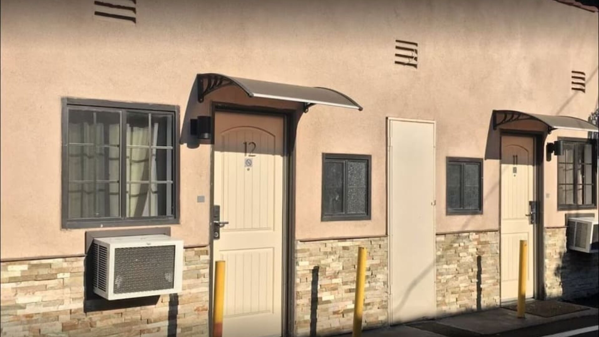 Exterior close-up of guest room entrances with private doors and outdoor corridor at Mid City Inn - Los Angeles.