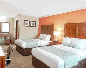 Double queen room with two beds, bedside lighting, vanity area, and patterned carpet at The Hills Inn Eagle Rock.