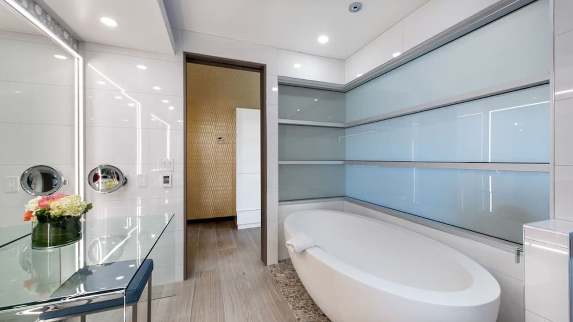 Contemporary bathroom with freestanding soaking tub, pebble flooring, and frosted glass wall panels at Shade Hotel Manhattan Beach.