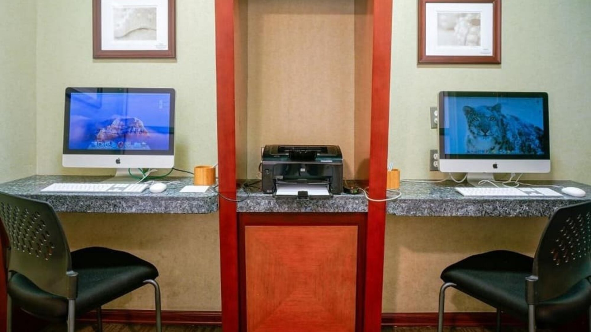 Business center with two desktop computers, printer station, and granite work counters at Shade Hotel Manhattan Beach.