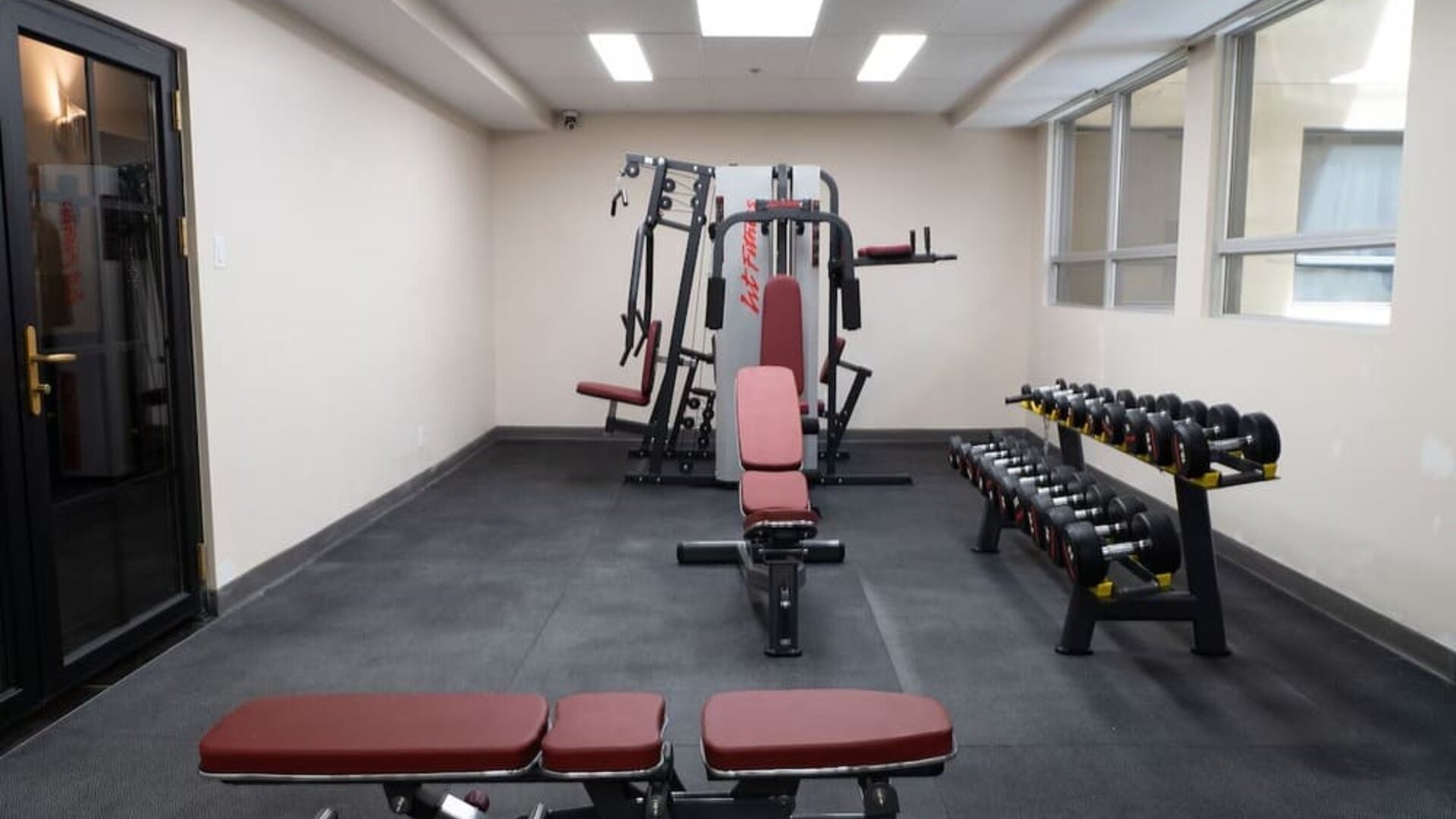Hotel gym with free weights and workout benches at Hotel Montreal Metropolitan, An Ascend Collection Hotel.