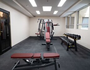 Hotel gym with free weights and workout benches at Hotel Montreal Metropolitan, An Ascend Collection Hotel.