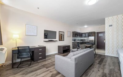 Spacious suite with living room, dining area, and full kitchenette at Hotel Montreal Metropolitan, An Ascend Collection Hotel.