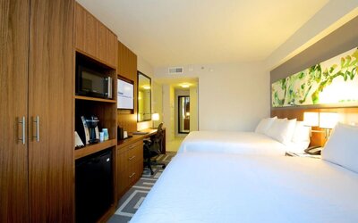 Spacious guest room with two double beds, workspace, and in-room amenities at Hilton Garden Inn New York Central Park South-Midtown West.