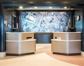 Modern reception desk and lobby area at Courtyard By Marriott New York JFK Airport.