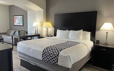 Guest room with seating area and workspace at La Quinta Inn & Suites By Wyndham Houston Energy Corridor.