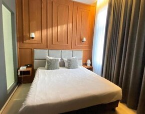 Cozy day room with large curtains and modern décor at Hôtel Espérance.