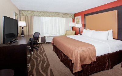 Spacious suite-style guest room with seating area and two beds at Holiday Inn Downtown Shreveport.