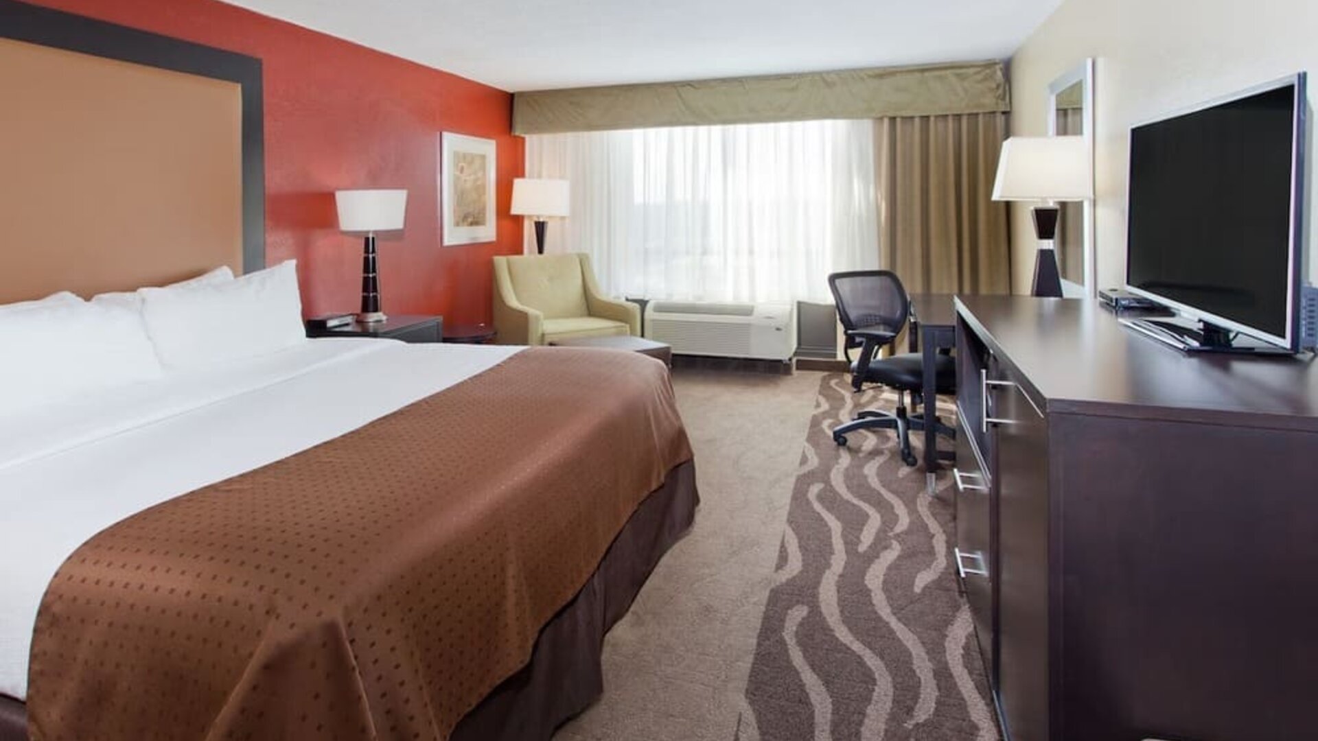 Bright guest room with natural light, workspace, and king bed at Holiday Inn Downtown Shreveport.