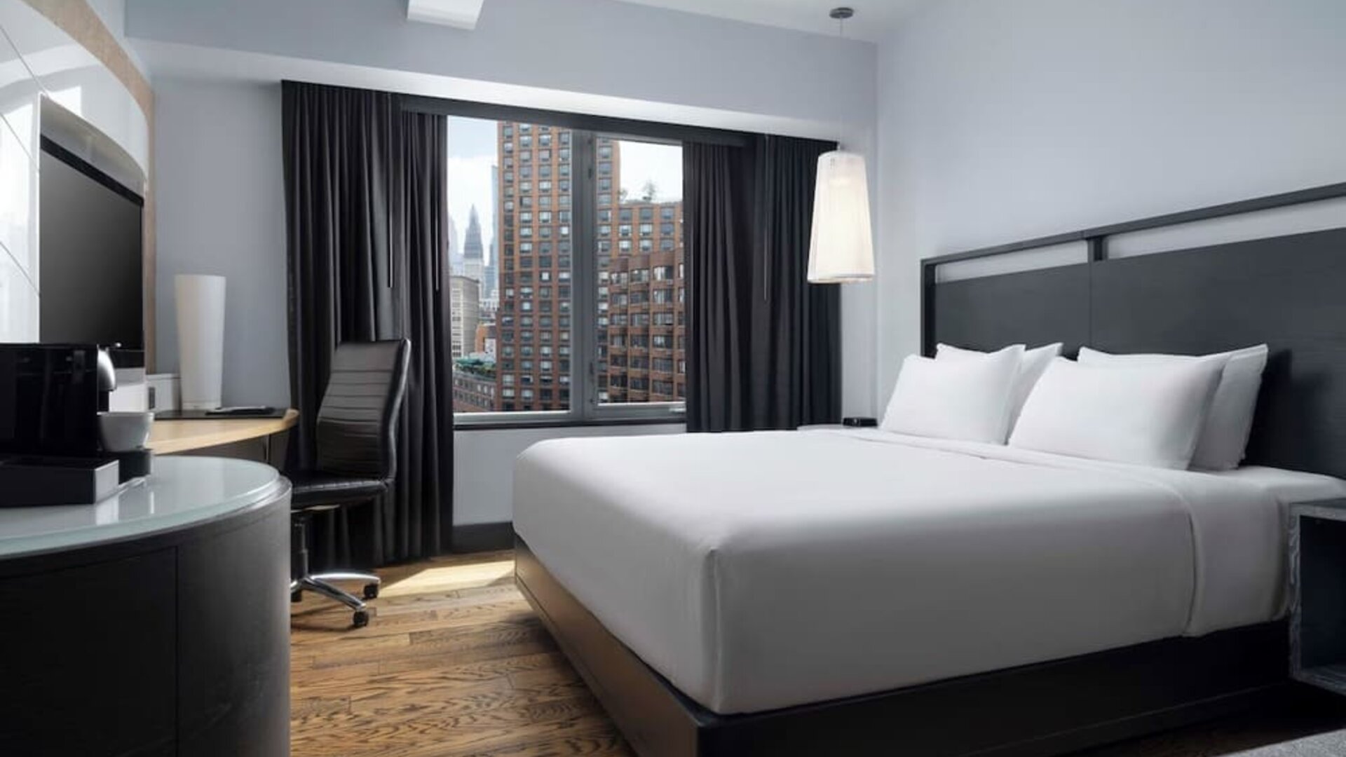 Contemporary guest room with king bed and large windows overlooking the city at Hyatt Union Square New York.