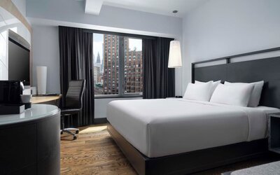 Contemporary guest room with king bed and large windows overlooking the city at Hyatt Union Square New York.