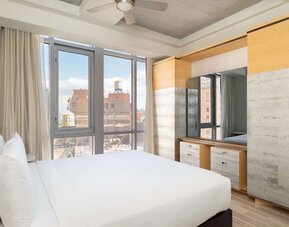 Bright guest room with floor-to-ceiling windows and modern furnishings at Hyatt Union Square New York.