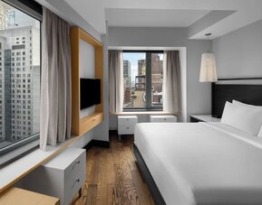 Stylish king guest room with minimalist furnishings and city skyline views at Hyatt Union Square New York.