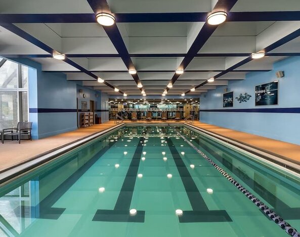 Indoor swimming pool with lap lanes and adjacent fitness area at Hyatt Regency Boston.