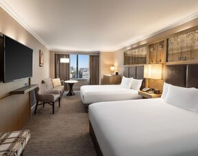 Spacious double queen guest room with city views, seating area, and large flat-screen TV at Hyatt Regency Boston.