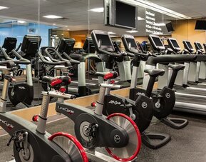 Fully equipped fitness center with treadmills, stationary bikes, and mirrored walls at Hyatt Regency Boston.